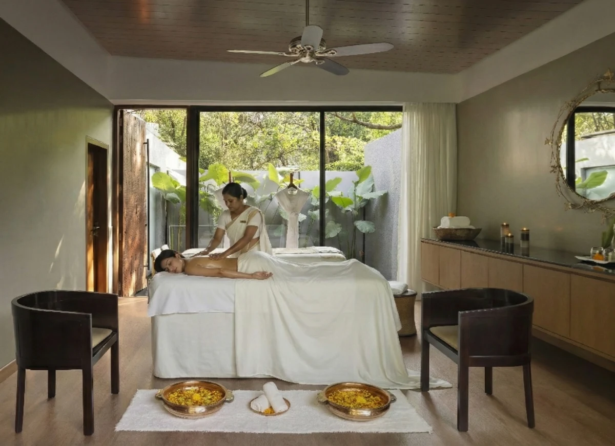 Guest receiving traditional Ayurvedic abhyanga oil massage treatment.