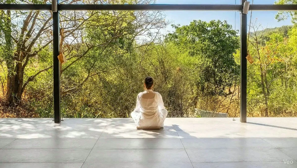 Guest practicing Yoga Nidra in peaceful meditation space with natural mountain views.