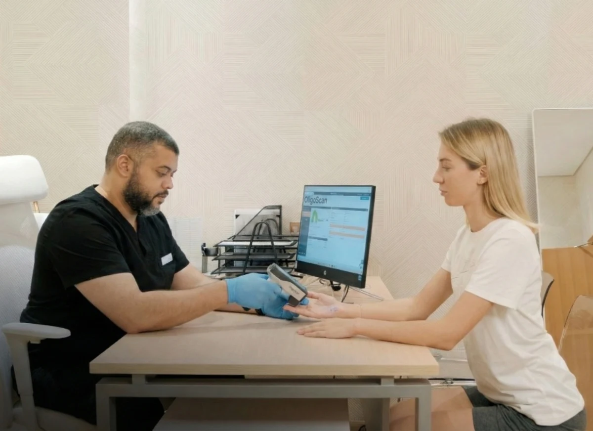 Doctor conducting Oligoscan cellular analysis on guest's palm.