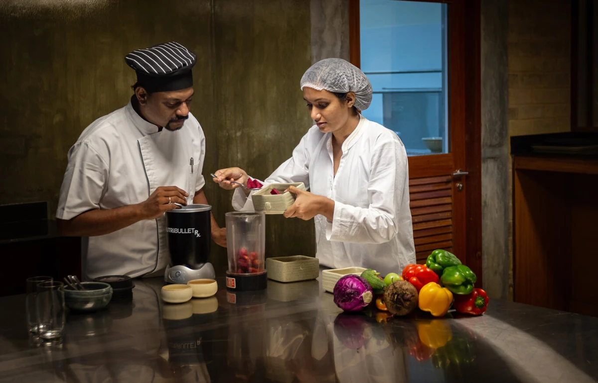 Chef preparing colorful raw food dishes & drinks in the fireless kitchen.