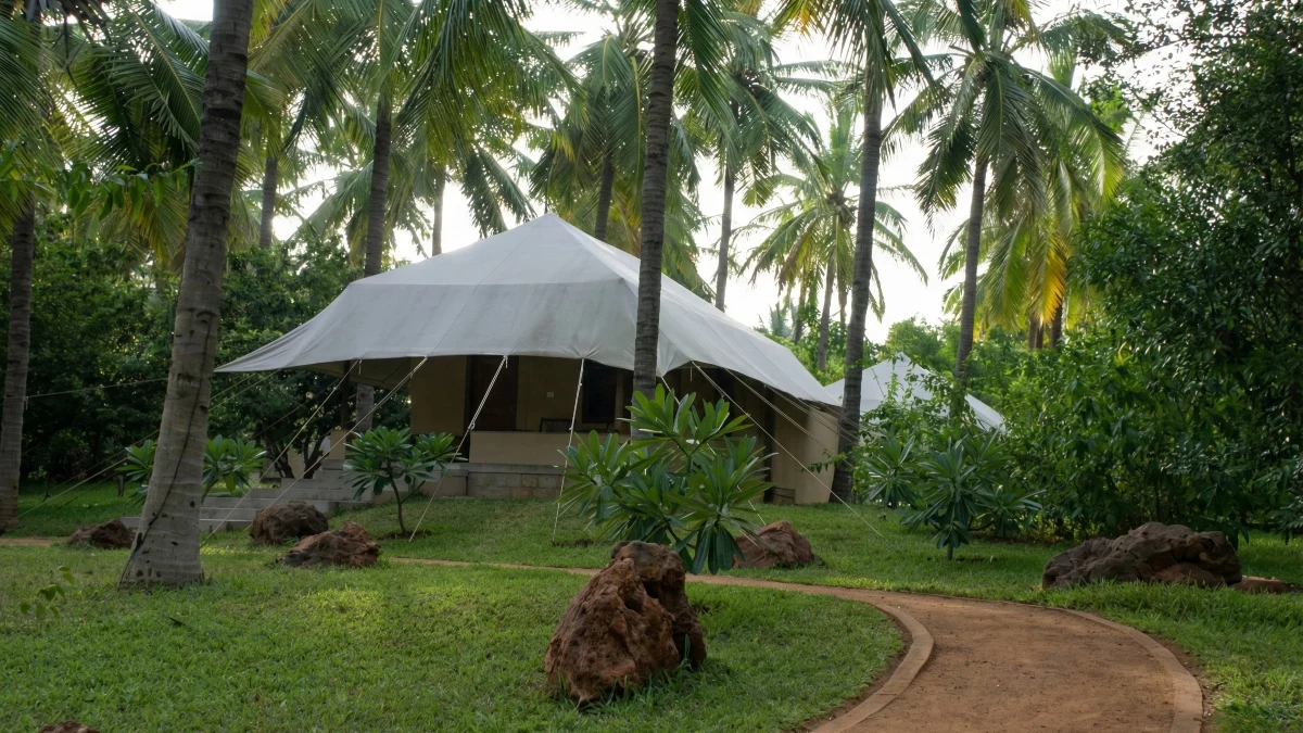 Garden tented cottage surrounded by pristine natural gardens and flowering plants.